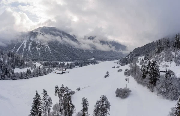 Vista aérea del viaducto de Landwasser con ferrocarril sin tren famoso en invierno, hito de Suiza, nevando, río y montañas — Foto de Stock