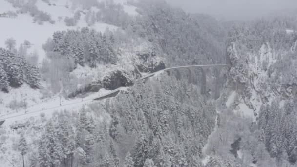 Luftaufnahme des Landwasserviadukts mit Bahn ohne Zug im Winter, Wahrzeichen der Schweiz, Schnee, Drohne fährt nicht — Stockvideo