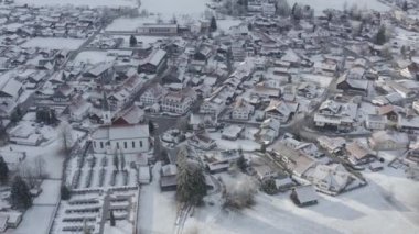 Kış mevsiminde gün doğumunda dağın dibindeki küçük Alman kasabasının hava manzarası Halblech şehri, Almanya, Bavyera, ağaçların dalları kıpkırmızı, güneşli havayla kaplıdır.