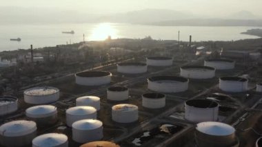 Günbatımında Kimya fabrikasının hava manzarası, petrol rafinerisi, duman, borular, ekoloji kirliliği, hava enfeksiyonu, Yunanistan 'da deniz kıyıları, petrol tankerlerinin yüklenmesi bekleniyor