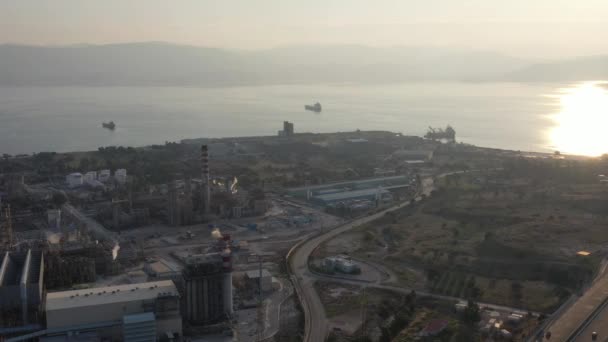 Luchtfoto van Chemische fabriek bij zonsondergang, olieraffinage, rook, pijpen, ecologie vervuiling, luchtinfectie, kust van de zee in Griekenland, olietankers verwachten laden — Stockvideo