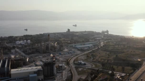 Luftaufnahme der Chemiefabrik bei Sonnenuntergang, Ölraffination, Rauch, Rohre, Umweltverschmutzung, Luftinfektion, Meeresküste in Griechenland, Öltanker erwarten Beladung — Stockvideo