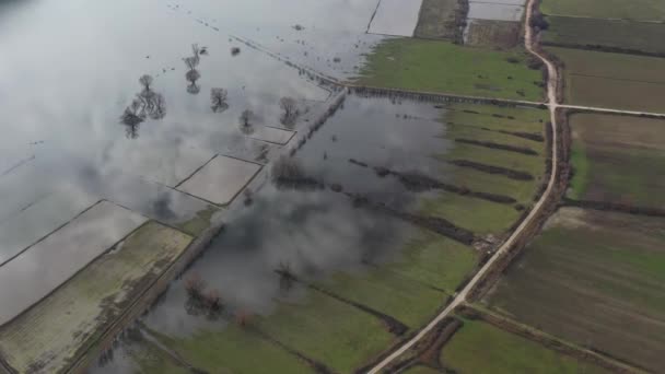 Lot nad zalaną doliną w Grecji. Zalane pola, drogi, góry na tle, osada zamieszkana. Odbicie gór w wodzie — Wideo stockowe