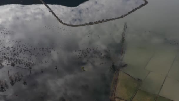 Vuelo sobre el valle inundado en Grecia. Los campos inundados, caminos, montañas en el fondo, el asentamiento habitado. Reflejo de montañas en el agua — Vídeos de Stock