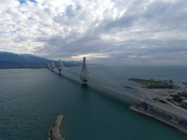 Yunanistan 'daki Rio Köprüsü' nün bulutlu hava ve feribot istasyonunda uzun süre kalan hava görüntüsü