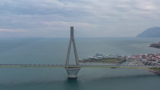Вид с воздуха на длинный кабельный мост Рио в Греции в облачную погоду, Паромная станция — стоковое видео