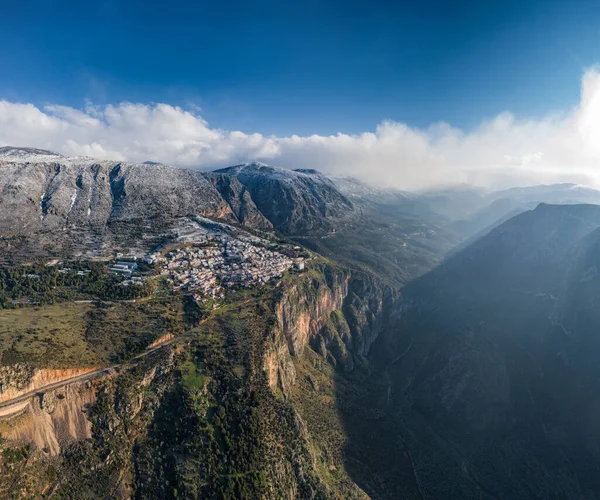 Widok z lotu ptaka Delphi, Grecja o wschodzie słońca, Zatoka Koryncka, Poranna mgła nad górami, chmróz na dachach, góra z wielowarstwowymi wzgórzami za dachem na pierwszym planie — Zdjęcie stockowe