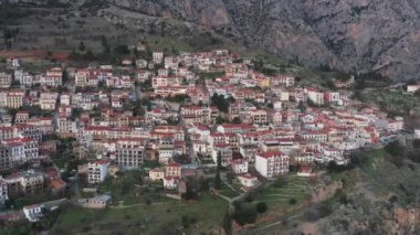 Delphi, Yunanistan 'ın havadan çekilmiş görüntüleri, turuncu renkler, ön planda çatıları olan katmanlı tepeler.