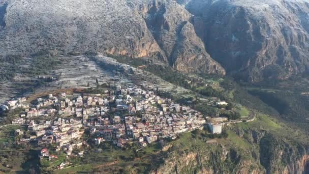 Flygfoto över Delfi, Grekland vid soluppgången, Korintbukten, Morgondimma över berg, hes på tak, bergssluttning med skiktade kullar bortom med hustak i förgrunden — Stockvideo