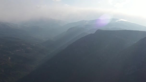 Gün doğumunda dağların havadan görünüşü, dağların üzerinden sabah sisi, güneş ışınları... — Stok video