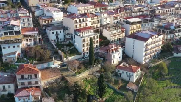 İnsansız hava aracı gün doğumunda terasta olan genç adamdan uçuyor, Delphi, Yunanistan, dağların üzerinde sabah sisi, çatılarda buz örtüsü — Stok video