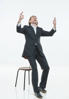 Siyah takım elbiseli yakışıklı genç adam koltukta, seviniyor, beyaz arkaplan, uzun saçlı vahşi adam, beyaz gömlekli, iş adamı, çok şık, mutlu.