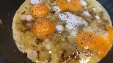 Birkaç yumurtadan kızarmış yumurta, soğan ve karabiber, sıvı yumurta beyazı, teflon kızartma tavası, kabarcık, buhar, omlet.