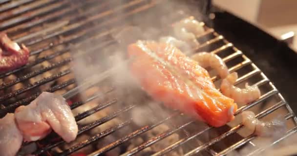 Em uma treliça uma grelha conservou o peixe, uma estaca, chama nua, brasas vermelhas, uma fumaça, lenha, as mãos do cozinheiro preparam o carvão, qualidade de hd ultra, vídeo 4k — Vídeo de Stock