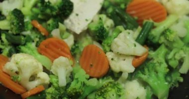 Taze kesilmiş sebzeler, kızartma tavasında kızartılmış havuçlar, karnabahar, brokoli, haricot, kızartma tavasının kapağının açılması.