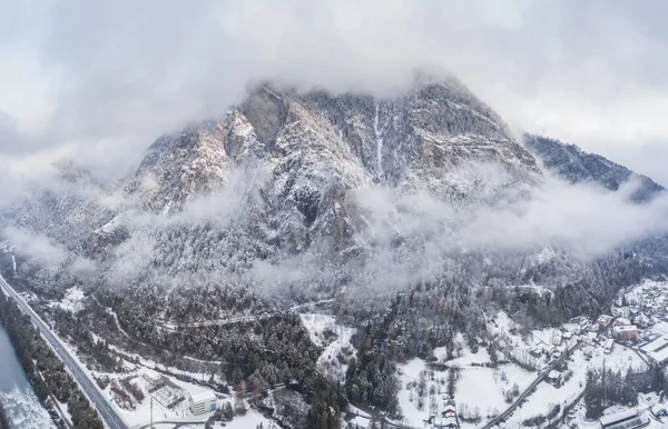 Vue aérienne de la montagne avec tour de démarcation, forêt sous le brouillard, pentes enneigées en Suisse, atmosphère nuageuse, belles conditions — Photo