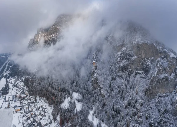 Veduta aerea della montagna con torre di confine, bosco sotto la nebbia, piste innevate in Svizzera, atmosfera nuvolosa, condizioni bellissime — Foto Stock