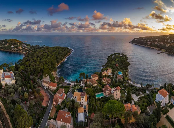 Francia, Saint-Jean-Cape-Ferrat, 15 de diciembre de 2019: Vista aérea del lugar más caro de la Riviera francesa al atardecer, terrazas de casas de campo y fincas, piscinas, salones Chaise, nubes rosas — Foto de Stock