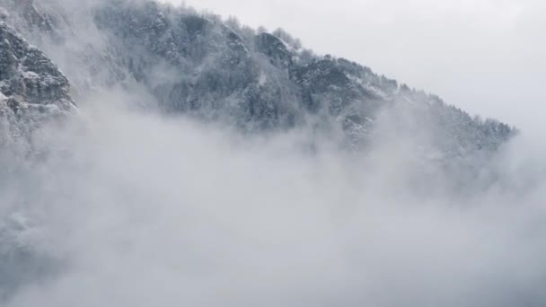 Utsikt over fjellet med grensetårn, skog under tåke, skråninger med snø dekket i Sveits, skyet atmosfære, vakre forhold – stockvideo