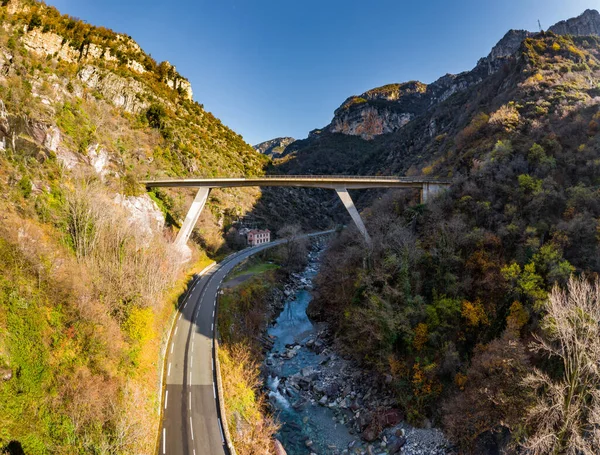 O rio de montanha ao longo da estrada, vista panorâmica aérea do drone de uma estrada scenic pela paisagem bonita coberta nas nuvens e no nevoeiro, ponte e viaduto, o rio de montanha ao longo da estrada , — Fotografia de Stock