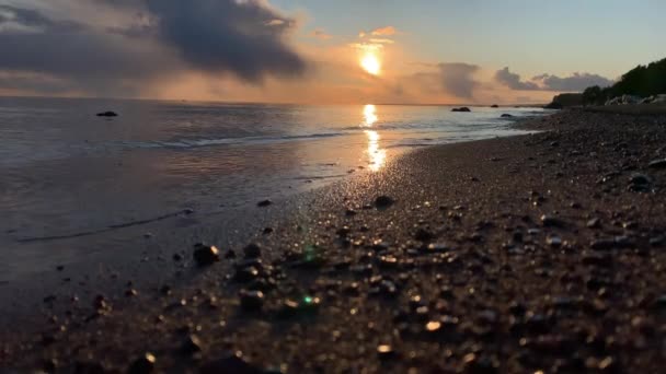 Kusten vid solnedgången, den pittoreska solnedgången, lugnt vatten, en sandstrand, moln lyses upp av solnedgången solen, Spekulärt reflektion i vatten — Stockvideo
