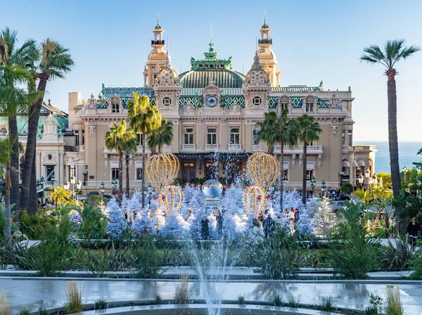 Monaco, Monte-Carlo, 25 de dezembro de 2019: The square Casino Monte-Carlo at sunset, white Christmas trees, hotel the Paris, sunny day, decoração de Natal, turistas, fonte, novos apartamentos, gramado verde — Fotografia de Stock