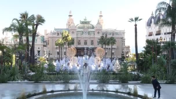 Mónaco, Montecarlo, 25 de diciembre de 2019: Panorama de la plaza Casino Monte Carlo al atardecer, árboles de Navidad blancos, hotel París, día soleado, decoración navideña, turistas, fuente, apartamentos nuevos — Vídeos de Stock