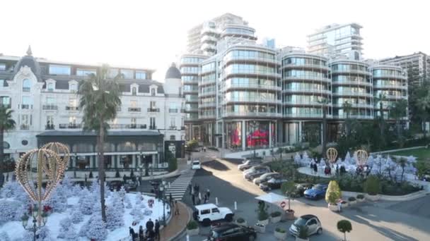 Monaco, Monte-Carlo, 25 december 2019: Panorama över torget Casino Monte-Carlo vid solnedgången, vita julgranar, hotell Paris, solig dag, juldekoration, turister, fontän, nya lägenheter — Stockvideo