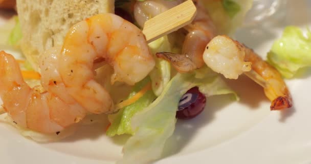 Grilled shrimp is on white plate with toasts, lemon and sauce, Thyme branch, leaf of salad — Stock Video