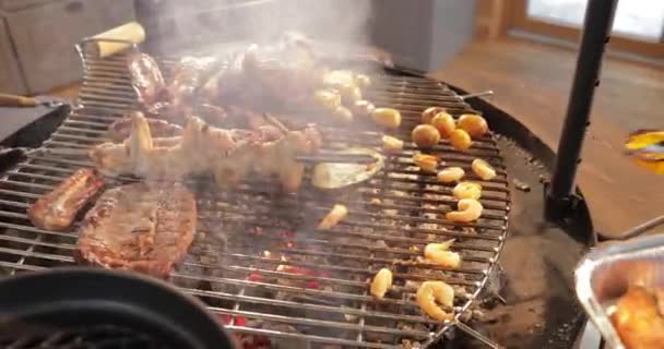 La carne se decapita en una rejilla de parrilla, unas costillas, una estaca, una salchichas, un borde, un pollo, llama desnuda, un pimiento dulce amarillo, pinzas de metal, el cocinero convierte la carne, un humo, leña, vapor, de cerca — Vídeos de Stock