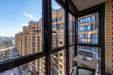 Balkondan yeni binaların renkli kompleksi, kitap bir masanın üzerinde, sandalye bir masanın yanında, çok renkli güzel tasarımın üst görüntüsü, araba parkı olan avlu.