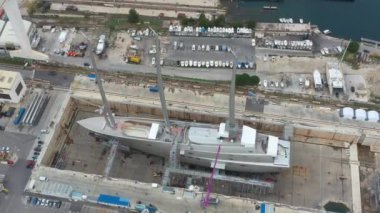 Fransa, La Ciotat, 18 Aralık 2019: Fransa 'nın La Ciotat şehrindeki deniz kuru rıhtımının havadan görünüşü, kargo vinci, tamir halindeki botlar, lüks bir yelken yatı ve motor yatı, arka planda dağ, tersane