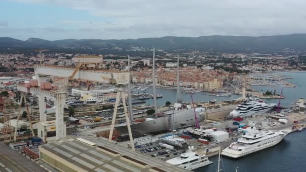 France, La Ciotat, 18 грудня 2019: Повітряний вид на морський сухий док в місті Ла-Сіотат, Франція, вантажний кран, човни на ремонті, розкішна вітрильна яхта і моторна яхта, гора на задньому плані, верф — стокове відео