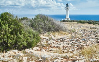 Lighthouse on the Formentera island, Spain, the blue sky with white clouds, without people, rocks, stones, sunny weather clipart