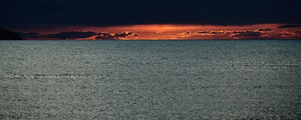 O pôr-do-sol dramático, o céu laranja, o mar tranquilo, o caminho solar, a gaivota — Fotografia de Stock