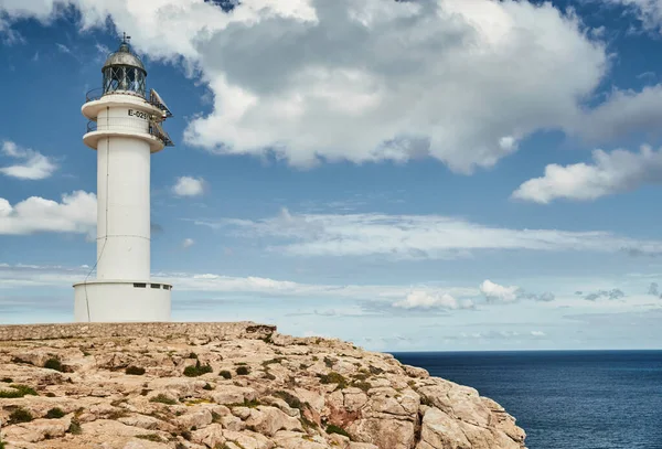 Leuchtturm auf Formentera, Spanien, blauer Himmel mit weißen Wolken, ohne Menschen, Felsen, Steine, sonniges Wetter — Stockfoto