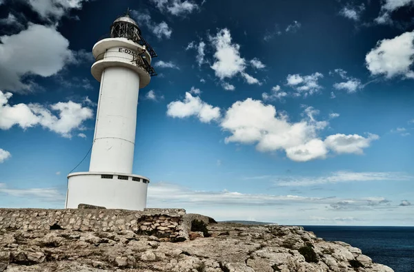 Leuchtturm auf Formentera, Spanien, blauer Himmel mit weißen Wolken, ohne Menschen, Felsen, Steine, sonniges Wetter — Stockfoto
