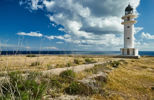 Leuchtturm auf Formentera, Spanien, blauer Himmel mit weißen Wolken, ohne Menschen, Felsen, Steine, sonniges Wetter — Stockfoto