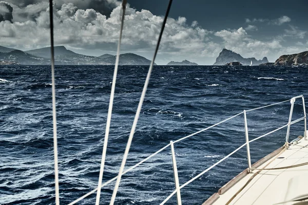 帆船からの海と山の景色、ボートのボードの端、スリングとロープ、ボートの下からのスプラッシュ、晴れた天気、劇的な空 — ストック写真