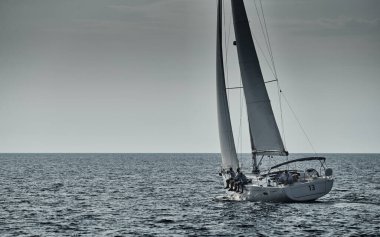 Yelkenli yelkenli gün batımında yelkenli yarışı, yelkenli yarışı, sudaki yelkenlerin yansıması, kıç tekneleri.