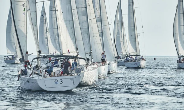 Kroatien, Mittelmeer, 18. September 2019: Segelboote messen sich bei einer Segelregatta, das Team schaltet das Boot aus, die Reflexion ist auf dem Wasser, weiße Segel, Bootsnummer achtern Boote, Strenger Wettbewerb — Stockfoto