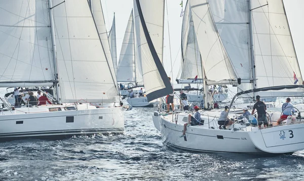 Croatia, Mediterranean Sea, 18 September 2019: Sailboats compete in a sailing regatta, the team turns off the boat, reflection is on water, white sails, boat number aft boats, Strained competition — Stock Photo, Image