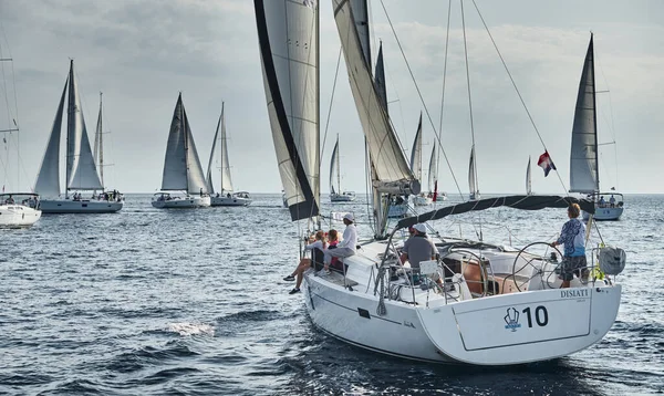 Kroatien, Mittelmeer, 18. September 2019: Segelboote messen sich bei einer Segelregatta, das Team schaltet das Boot aus, die Reflexion ist auf dem Wasser, weiße Segel, Bootsnummer achtern Boote, Strenger Wettbewerb — Stockfoto