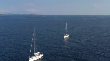 Bir yat yarışının katılımcılarının sıralaması başlangıç noktasında, Hırvatistan 'da bir yelkencilik yarışı, sudaki yelkenlerin yansıması, kıç tekneleri