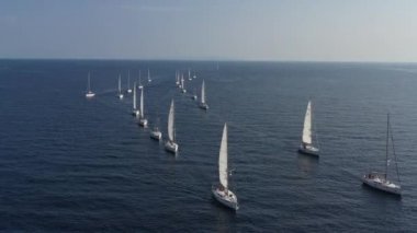 Bir yat yarışının katılımcılarının sıralaması başlangıç noktasında, Hırvatistan 'da bir yelkencilik yarışı, sudaki yelkenlerin yansıması, kıç tekneleri