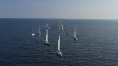 Bir yat yarışının katılımcılarının sıralaması başlangıç noktasında, Hırvatistan 'da bir yelkencilik yarışı, sudaki yelkenlerin yansıması, kıç tekneleri