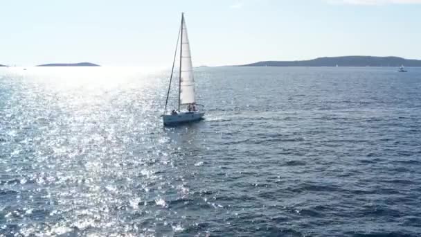 Deux yachts à voile proches les uns des autres, les jeunes s'amusent sur des yachts, les jeunes accrochent à une corde entre les bateaux, la mer Adriatique, la Croatie, les îles sur un fond, les reflets du soleil sur l'eau, calme — Video