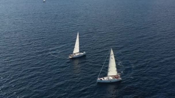 Two sailing yachts closely to each other, youth have fun on yachts, young people hang on a rope between boats, the Adriatic Sea, Croatia, islands on a background, sun reflections on water, calm — Stock Video