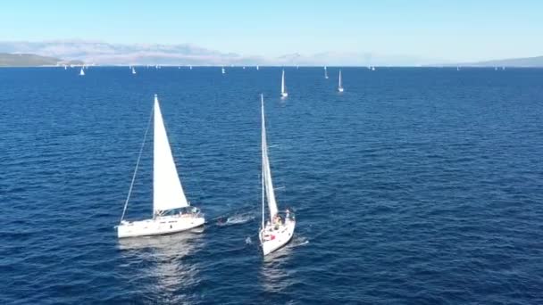 Two sailing yachts closely to each other, youth have fun on yachts, young people hang on a rope between boats, the Adriatic Sea, Croatia, islands on a background, sun reflections on water, calm — Stock Video