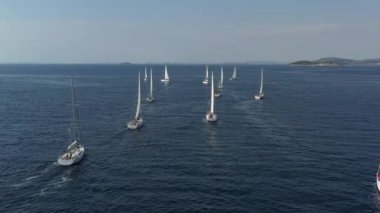 Bir yat yarışının katılımcılarının sıralaması başlangıç noktasında, Hırvatistan 'da bir yelkencilik yarışı, sudaki yelkenlerin yansıması, kıç tekneleri